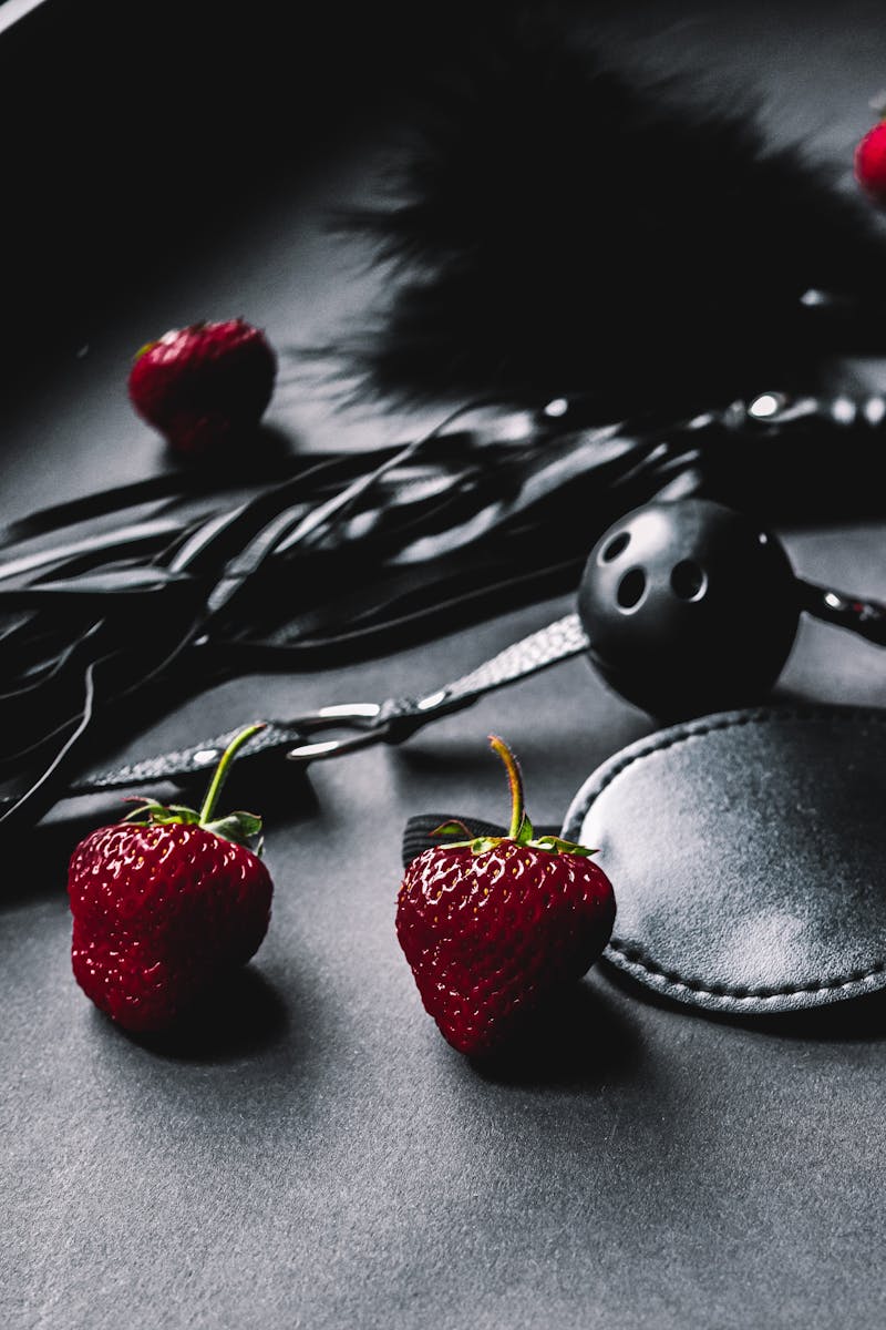 Strawberries Lying Next to Leather Erotic Toys